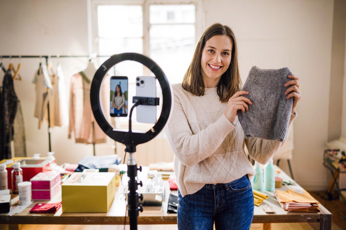 A seller filming a product video for social media in her home studio
